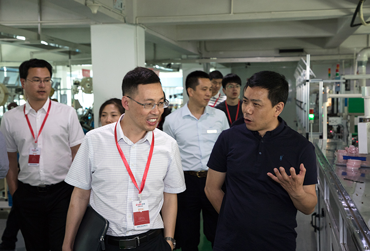 欣灵公司总裁张彭春（右一）陪同市委领导参观车间